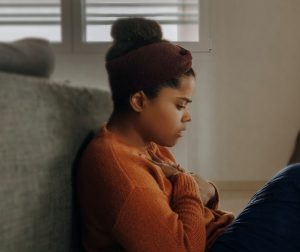 teen-leans-against-sofa-on-floor