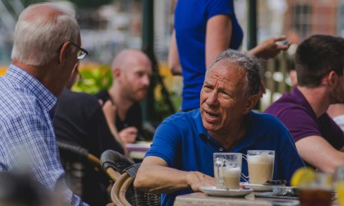Older men chatting over a coffee outdoors
