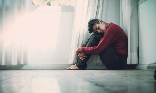 Young man sat on the floor looking distressed